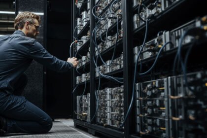 Engineer adjusting Bitcoin mining servers in a data center amid network power struggle over anti-spam proposal and disputed node support
